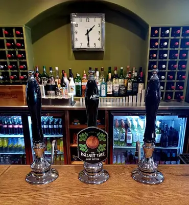 two bottles of beer sitting on top of a bar at the walnut tree in Worlington