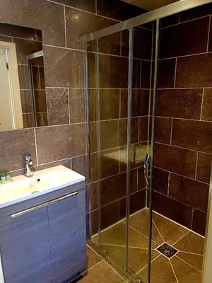 a bathroom with a glass shower and a sink at the walnut tree in Worlington
