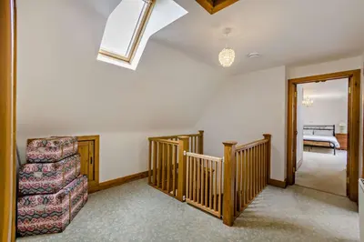 a living room with stairs and a chair at Finest Retreats - The House at No 47 in West Wickham