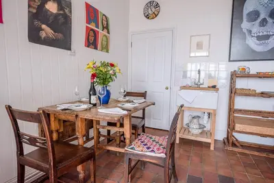 a dining room with a wooden table and chairs at Art Cottage, Aldeburgh in Aldeburgh