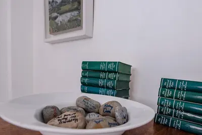 a plate of rocks on a table with books at Art Cottage, Aldeburgh in Aldeburgh