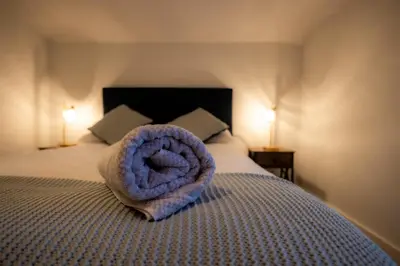 a bed with a large purple towel on it at High Street 200A in Wickham Market