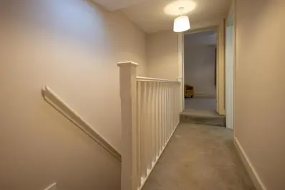a hallway with stairs and a light on the wall at High Street 200A in Wickham Market