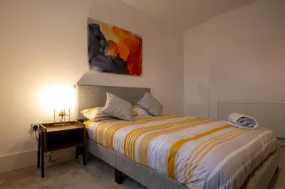 a bedroom with a bed and a painting on the wall at High Street 200A in Wickham Market