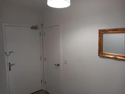 a room with two white doors and a mirror at Richfield Lux in Loughton
