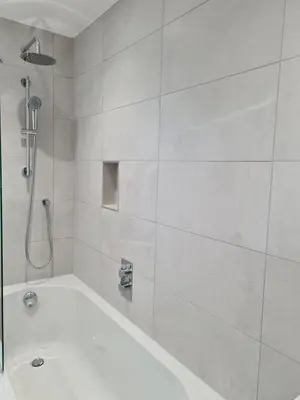 a white bathroom with a tub and a shower at Modern Cambridge Flat-Easy A14 Access and City Links in Milton