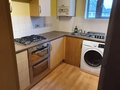 a kitchen with a washing machine and a washer at Modern Cambridge Flat-Easy A14 Access and City Links in Milton