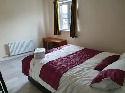 a bedroom with a large bed and a window at Modern Cambridge Flat-Easy A14 Access and City Links in Milton