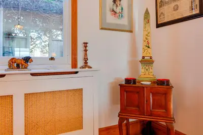 a living room with a fireplace and a table at Pass the Keys Charming Cottage in the City Centre Free Parking in Cambridge