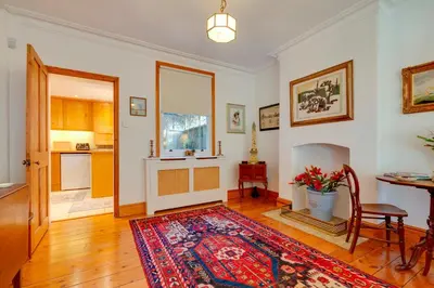 a living room with a table and a rug at Pass the Keys Charming Cottage in the City Centre Free Parking in Cambridge