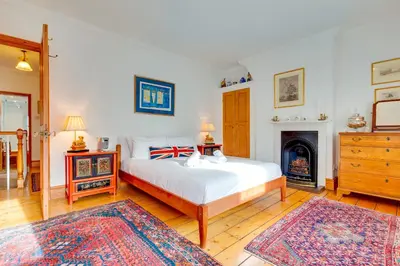 a bedroom with a white bed and a fireplace at Pass the Keys Charming Cottage in the City Centre Free Parking in Cambridge