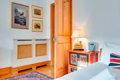 a bedroom with a bed and a table with a lamp at Pass the Keys Charming Cottage in the City Centre Free Parking in Cambridge