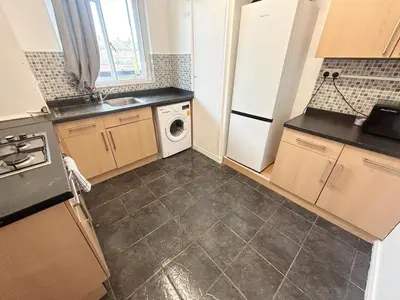 a kitchen with a white refrigerator and a dishwasher at Essex Apartment in Loughton
