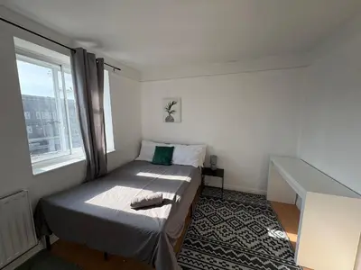 a small bedroom with a bed and a window at Essex Apartment in Loughton