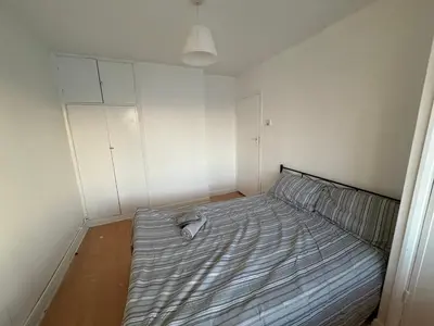 a small bedroom with a bed in the corner at Essex Apartment in Loughton