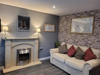 a living room with a couch and a fireplace at The Nook in Great Cornard