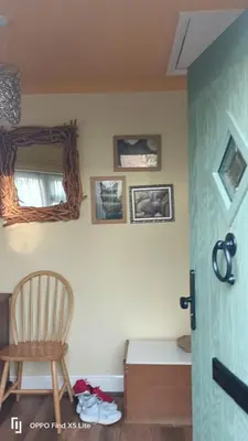 a room with a chair and a bed and a mirror at Dolphin cottage in Nevendon
