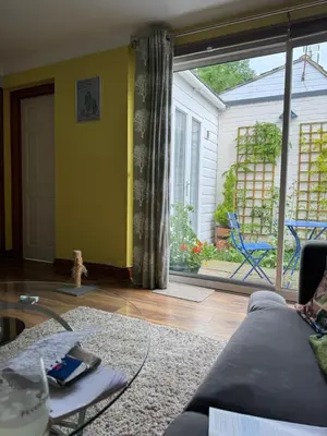 a living room with a couch and a large window at Dolphin cottage in Nevendon