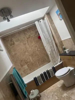 an overhead view of a bathroom with a toilet and a shower at Dolphin cottage in Nevendon