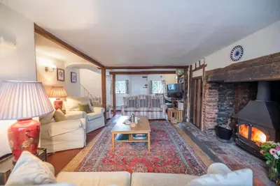 a living room with a couch and a fireplace at Varley House, Saxmundham in Saxmundham