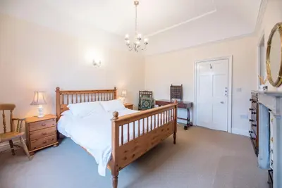 a bedroom with a bed and a dresser and a mirror at Varley House, Saxmundham in Saxmundham