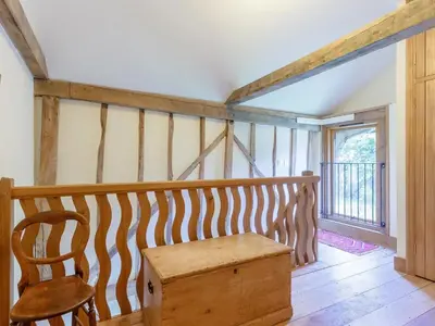 a room with a wooden table and a chair at Colemans Farm Barn- Unique, Rustic & Peaceful Barn - Essex countryside in Finchingfield