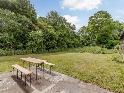a picnic table and two benches in a field at Colemans Farm Barn- Unique, Rustic & Peaceful Barn - Essex countryside in Finchingfield