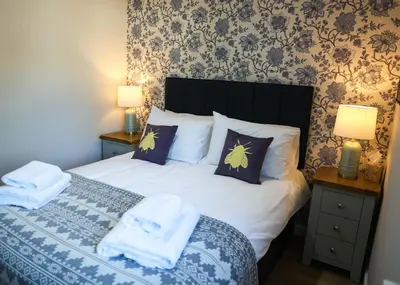 a bedroom with a bed with towels on it at Bramley Suite - The Apple Barn in Pettistree