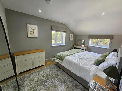 a bedroom with a bed and two windows at Bramley Suite - The Apple Barn in Pettistree