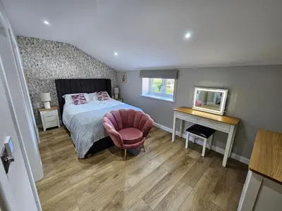 a bedroom with a bed and a chair and a desk at Bramley Suite - The Apple Barn in Pettistree