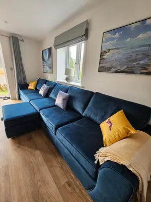 a blue leather couch in a living room at Bramley Suite - The Apple Barn in Pettistree