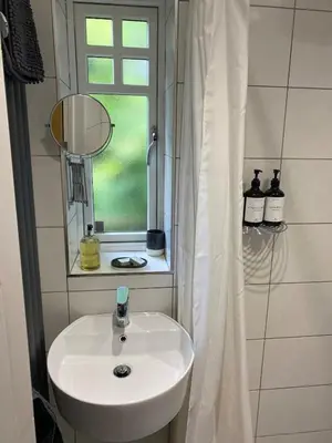 a bathroom with a white sink and a window at Primrose Lodge in Maldon in Maldon