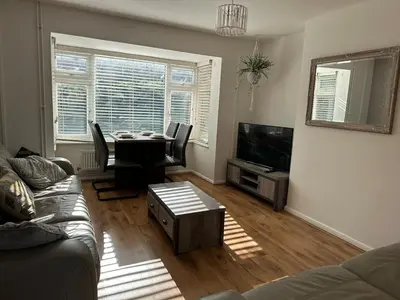 a living room with a couch and a table and a television at Place to stay up Ipswich near the train station, football stadium, waterfront in Ipswich