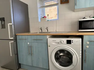 a kitchen with a washing machine and a sink at Place to stay up Ipswich near the train station, football stadium, waterfront in Ipswich