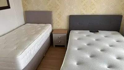 a bedroom with two twin beds and a night stand at Place to stay up Ipswich near the train station, football stadium, waterfront in Ipswich
