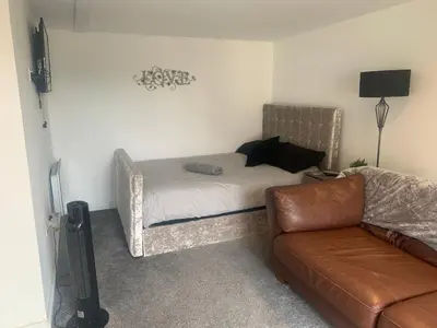 a living room with a bed and a couch at Sunnyside guest house in Latchingdon and Snoreham