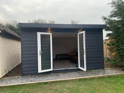 a black shed with a door open on a yard at Sunnyside guest house in Latchingdon and Snoreham