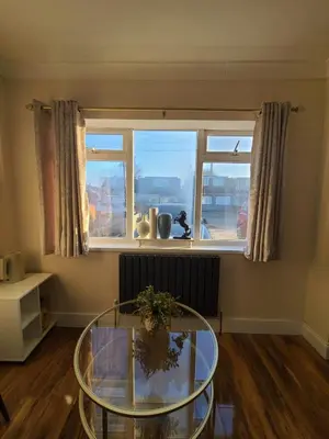 a living room with a glass table in front of a window at One Bed and Bath in Rochford in Rochford