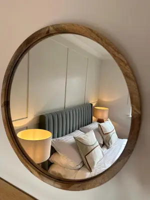a mirror reflecting a bed with pillows at Detached Luxury Coach House - Sky Sports Cinema - EVCharger in Colchester