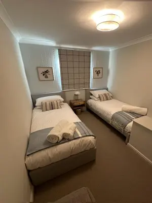 a bedroom with two beds and a mirror at Detached Luxury Coach House - Sky Sports Cinema - EVCharger in Colchester