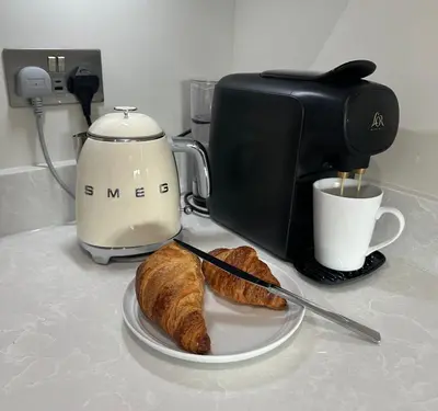 a counter with a coffee maker and a plate of bread at Detached Luxury Coach House - Sky Sports Cinema - EVCharger in Colchester
