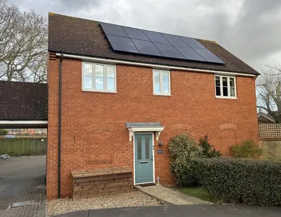 a red brick house with solar panels on the roof at Detached Luxury Coach House - Sky Sports Cinema - EVCharger in Colchester