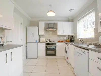 a white kitchen with white appliances and white cabinets at 51 Halesworth in Holton