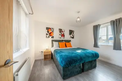 a bedroom with a bed and two windows at Cambridge 5 Bedrooms Sleeps 10 Free Parking 4 Bathrooms in Long Stanton