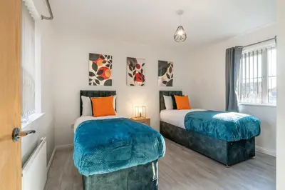 a bedroom with two beds and a window at Cambridge 5 Bedrooms Sleeps 10 Free Parking 4 Bathrooms in Long Stanton