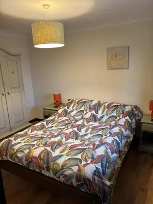 a bed with a colorful comforter in a room at Fushia Chalet a lovely little rural retreat in Saxtead