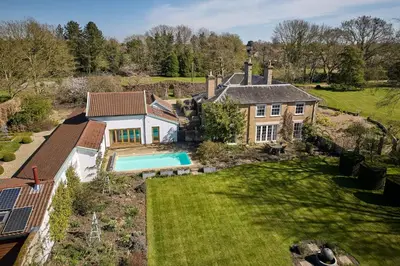 an aerial view of a house with a swimming pool at Hockham Grange in Hockham