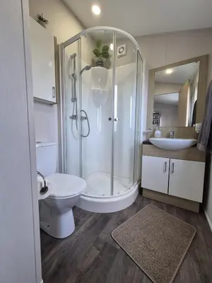a bathroom with a shower and a toilet and a sink at The Retreat 2 bedroom lodge with sauna! in Walton-on-the-Naze