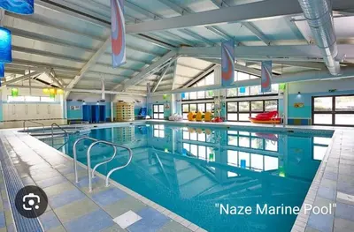 a large swimming pool in a building at The Retreat 2 bedroom lodge with sauna! in Walton-on-the-Naze