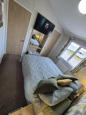 a small bedroom with a bed with pillows on it at The Retreat 2 bedroom lodge with sauna! in Walton-on-the-Naze